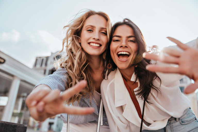 deux femmes prennent des photos et rient