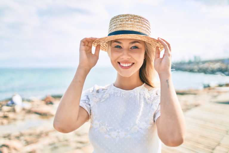 une femme souriante avec un chapeau sur la tête