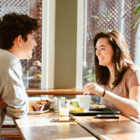 un homme et une femme sont assis à une table et parlent