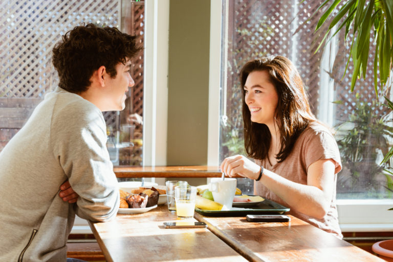 un homme et une femme sont assis à une table et parlent