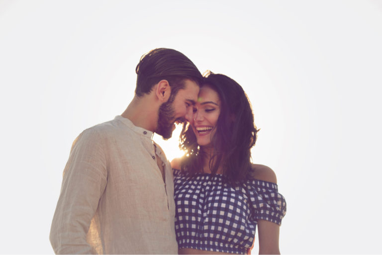 un beau couple souriant debout embrassant