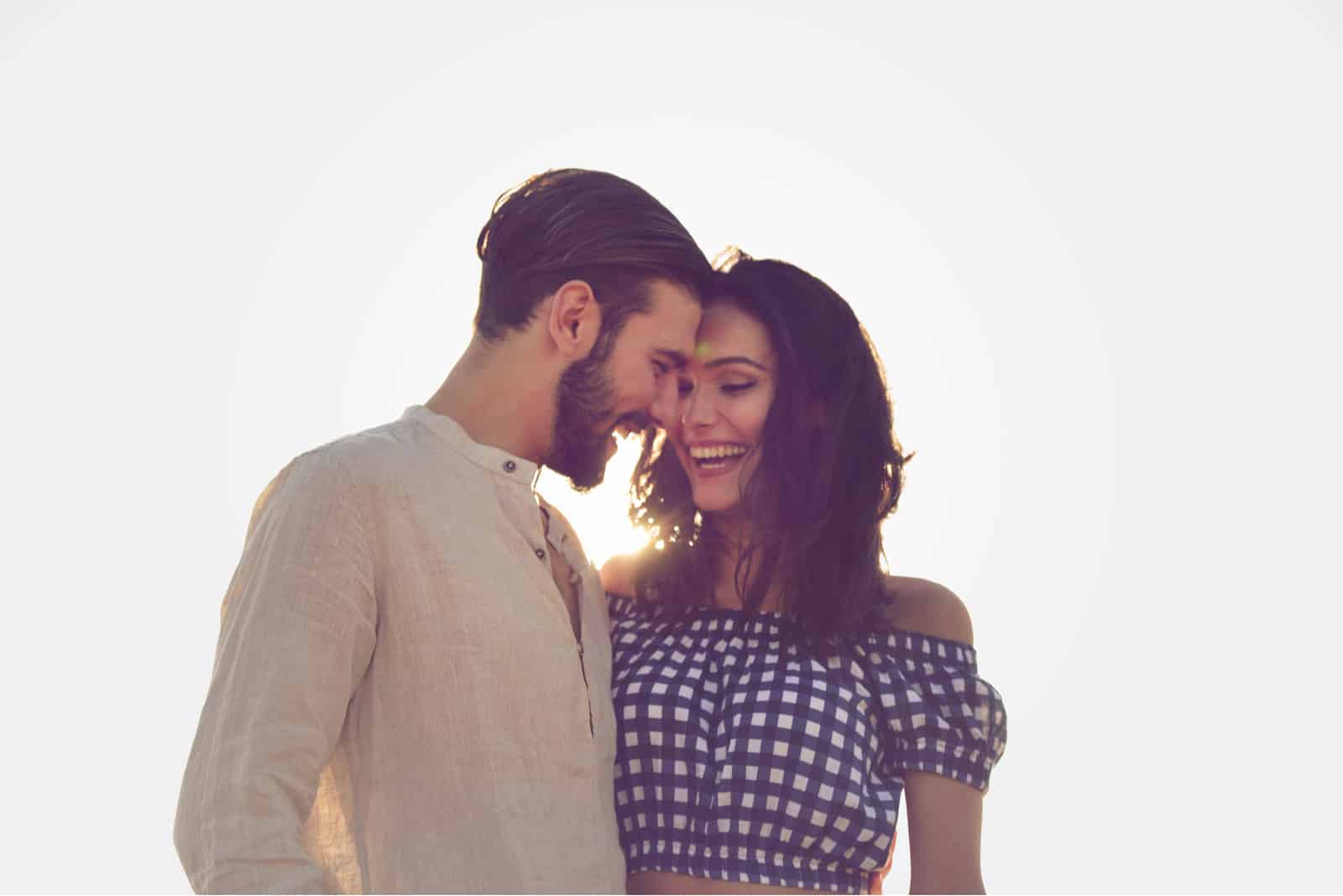 un beau couple souriant debout embrassant