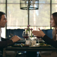un homme et une femme sont assis à une table et se disputent