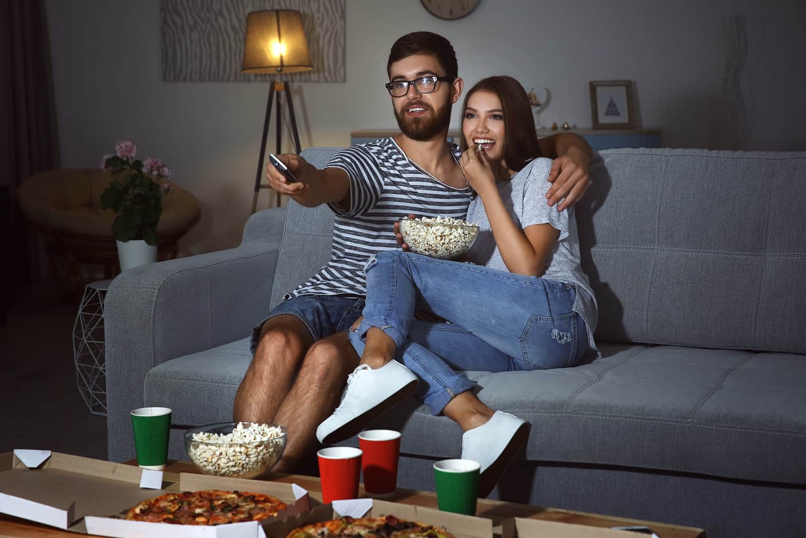 un homme et une femme mangeant du pop-corn et regardant la télévision