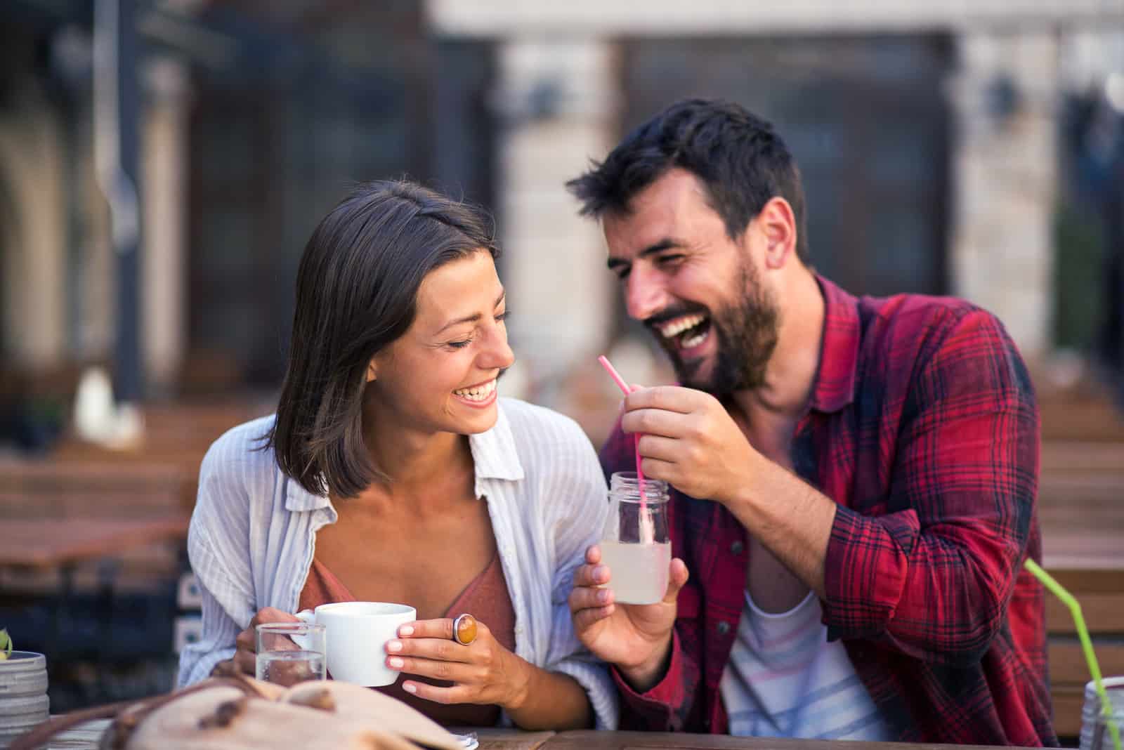 un homme souriant tient une limonade et parle à une femme