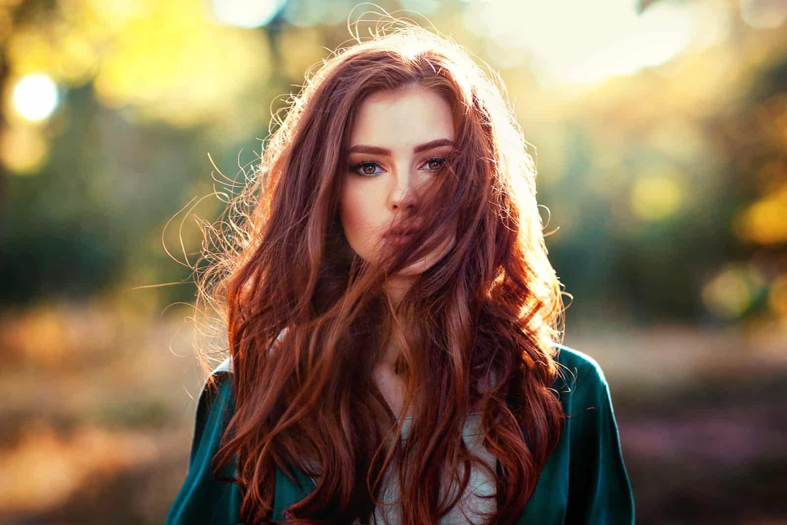 une femme aux longs cheveux roux se dresse