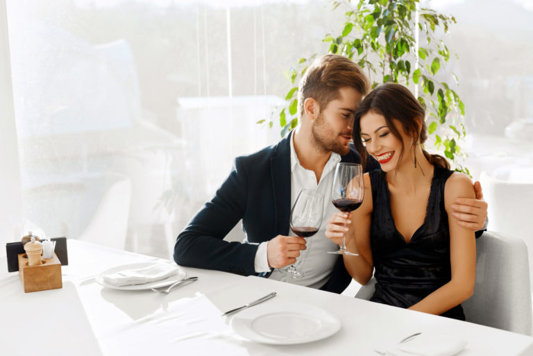 un homme et une femme s'embrassent assis à une table