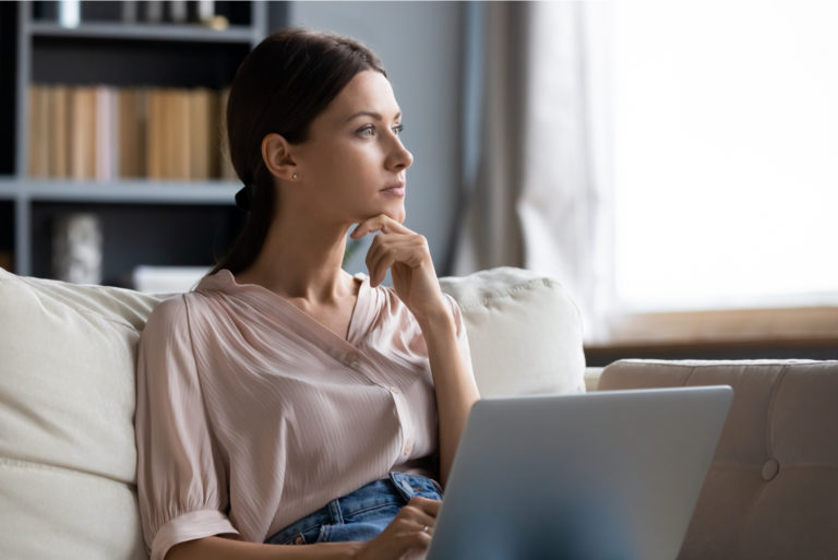 une femme imaginaire assise derrière un ordinateur portable