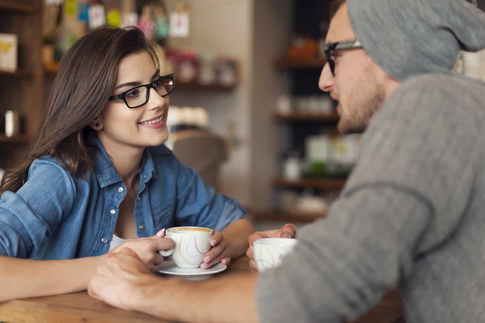 un homme et une femme discutent dans un café