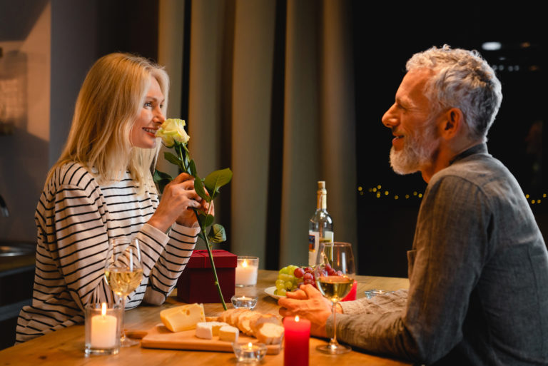 un homme et une femme assis à une table buvant du vin