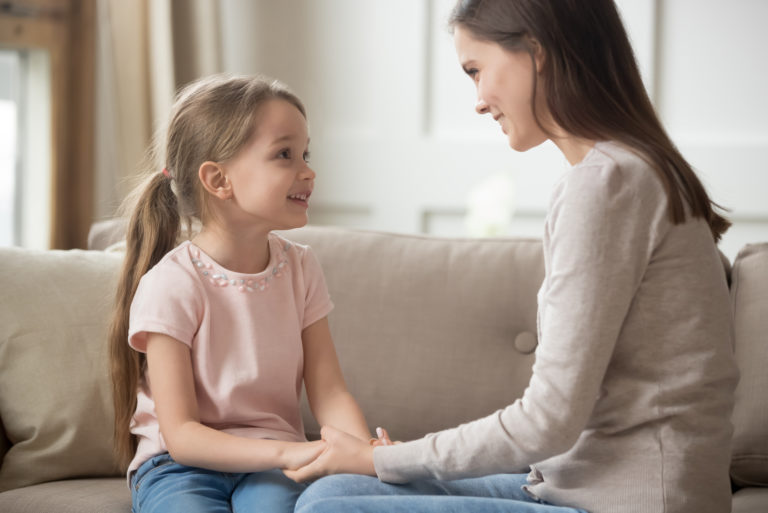 maman et sa fille s'assoient sur le canapé et parlent