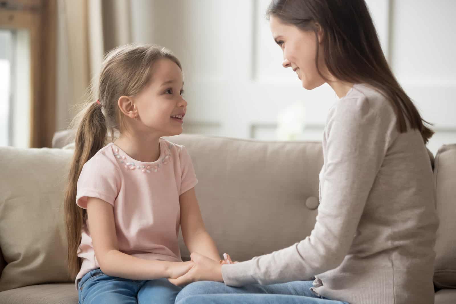 maman et sa fille s'assoient sur le canapé et parlent