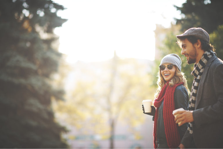 une femme souriante marche dans la rue avec un homme