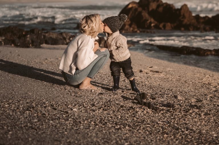 mère embrassant son fils au bord de la mer