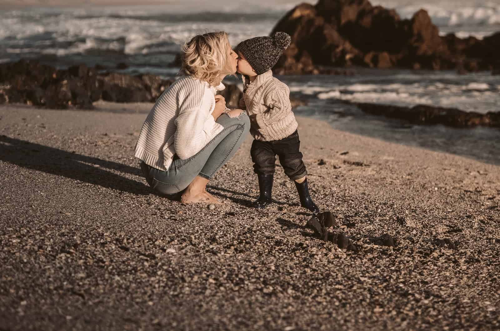 mère embrassant son fils au bord de la mer