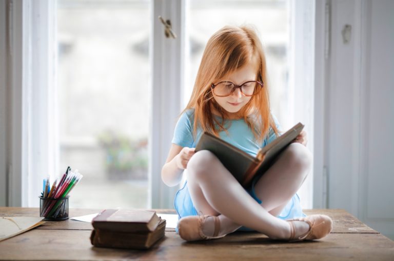 fille au gingembre lisant un livre par la fenêtre
