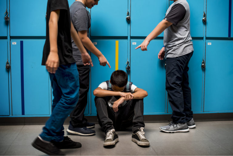 garçon se faisant intimider dans le couloir à l'école