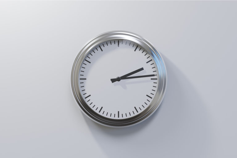 une horloge sur un mur gris