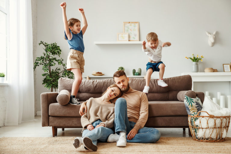 parents assis par terre pendant que les enfants sautent
