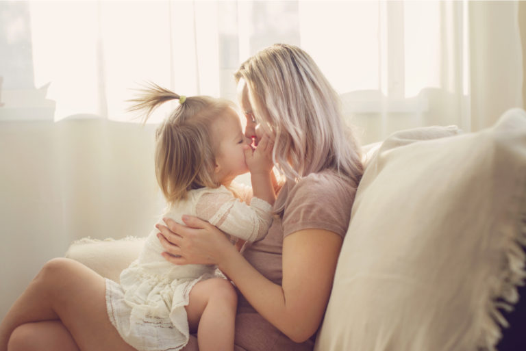 mère et fille câlins sur canapé