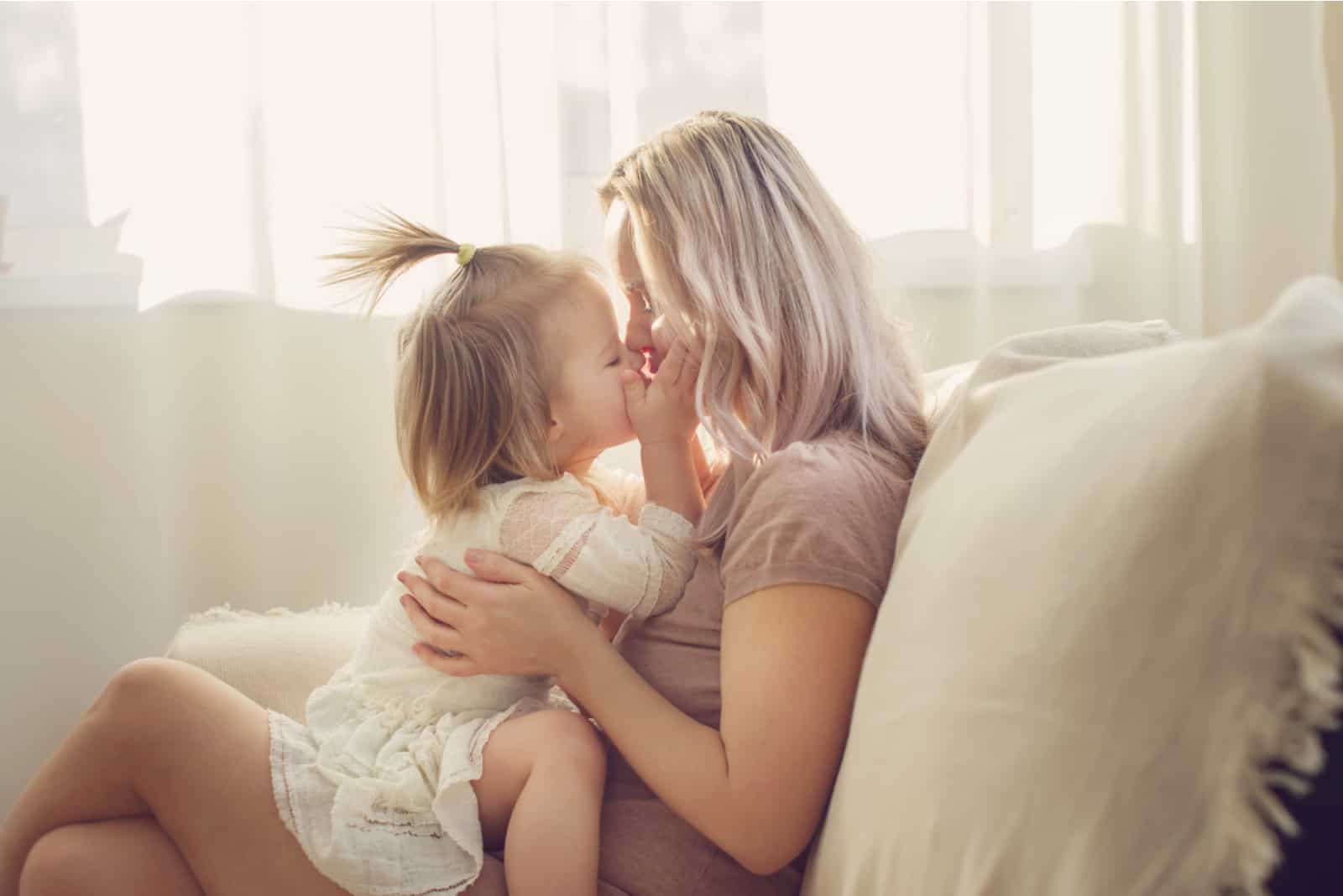 mère et fille câlins sur canapé