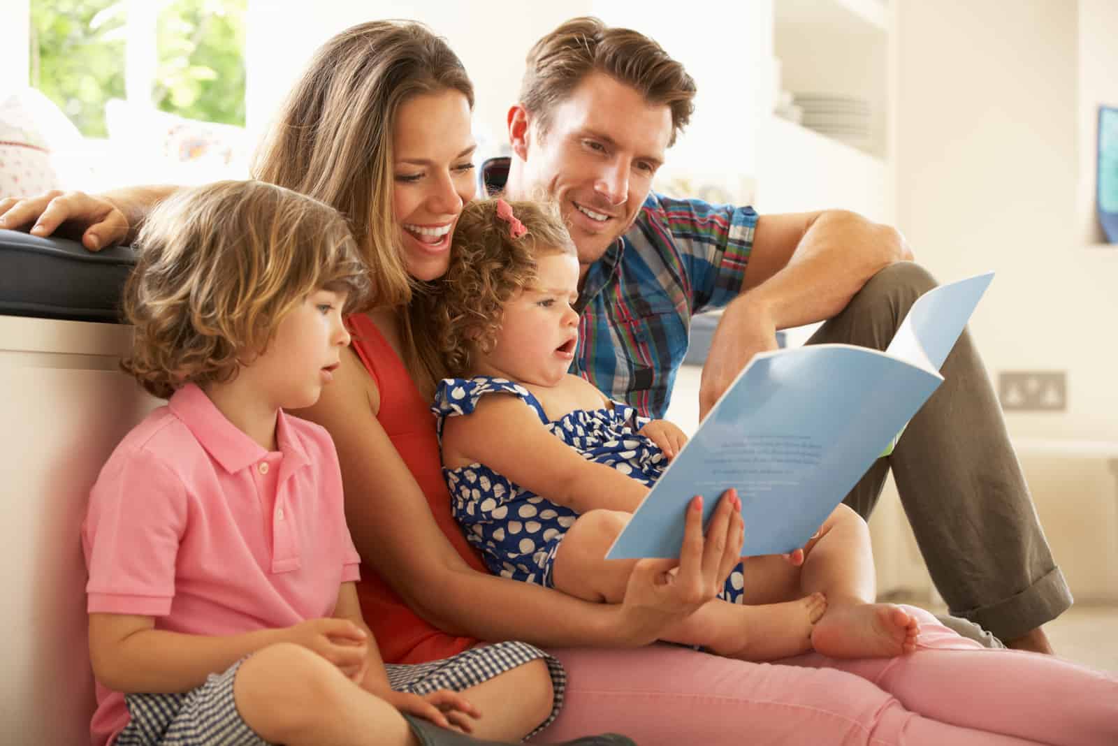 Famille assise sur le sol en lisant un livre
