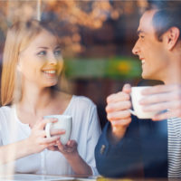 couple d'amoureux souriant prenant un café en train de parler