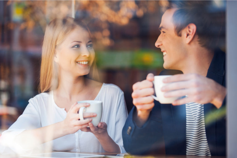 couple d'amoureux souriant prenant un café en train de parler