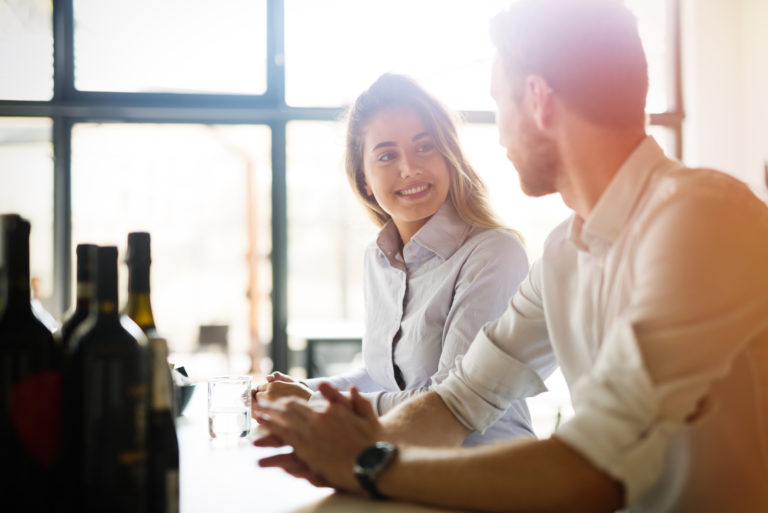 un homme et une femme sont assis à une table et se regardent
