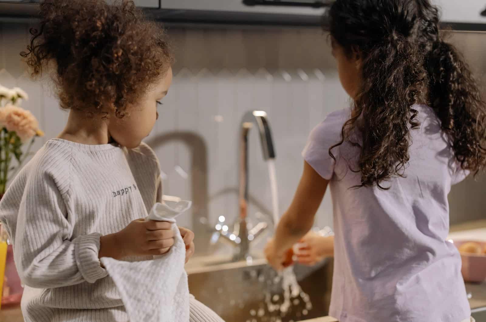 deux petites filles lavant la vaisselle dans la cuisine