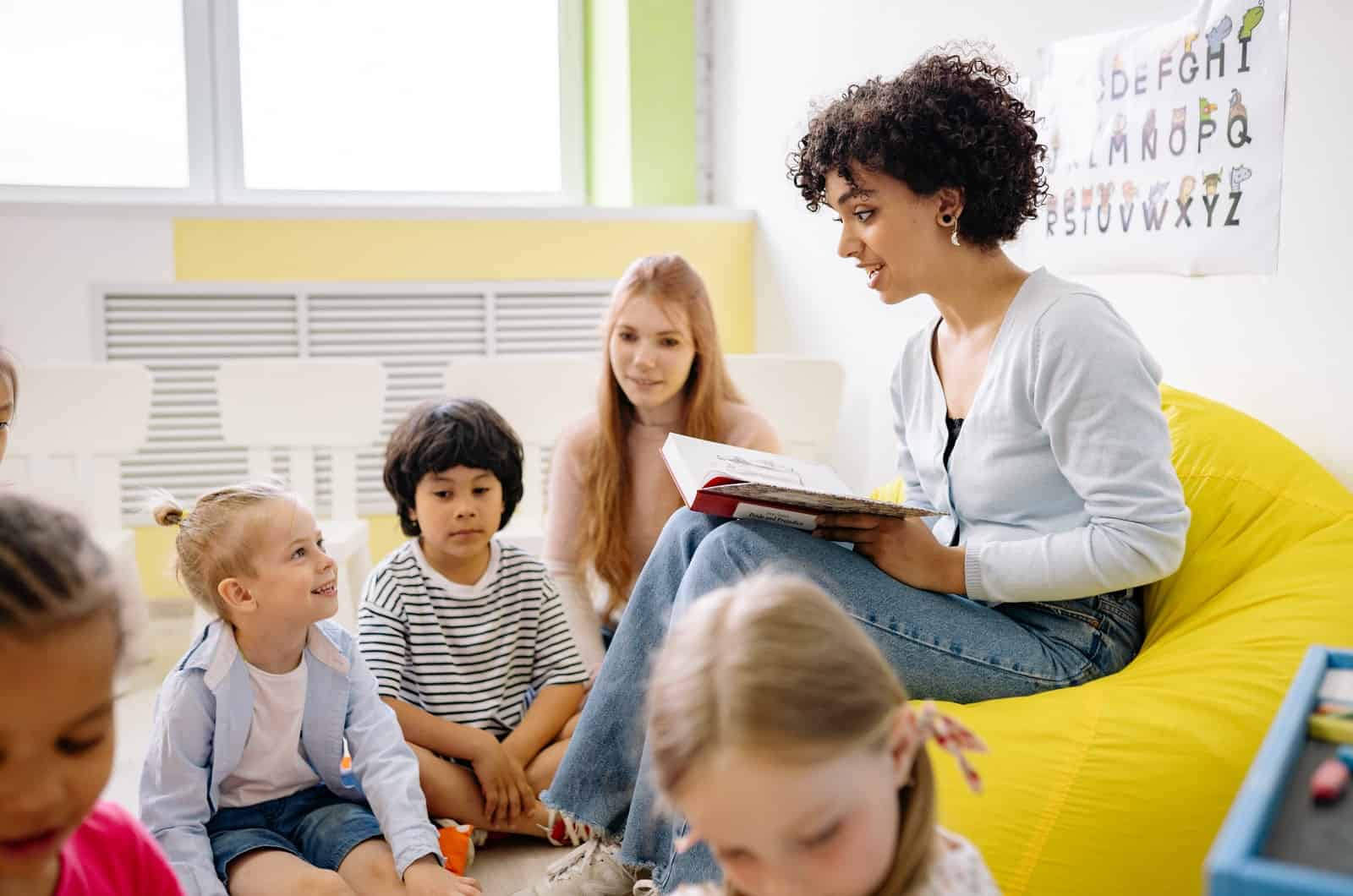 femme lisant un livre aux enfants en classe