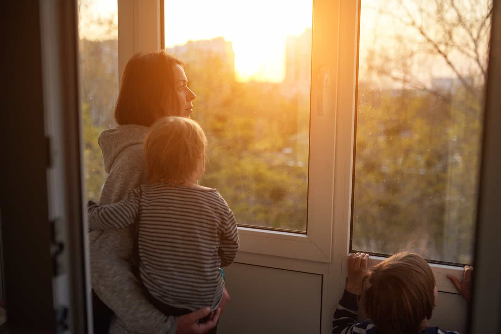 mère et enfants regardant par la fenêtre