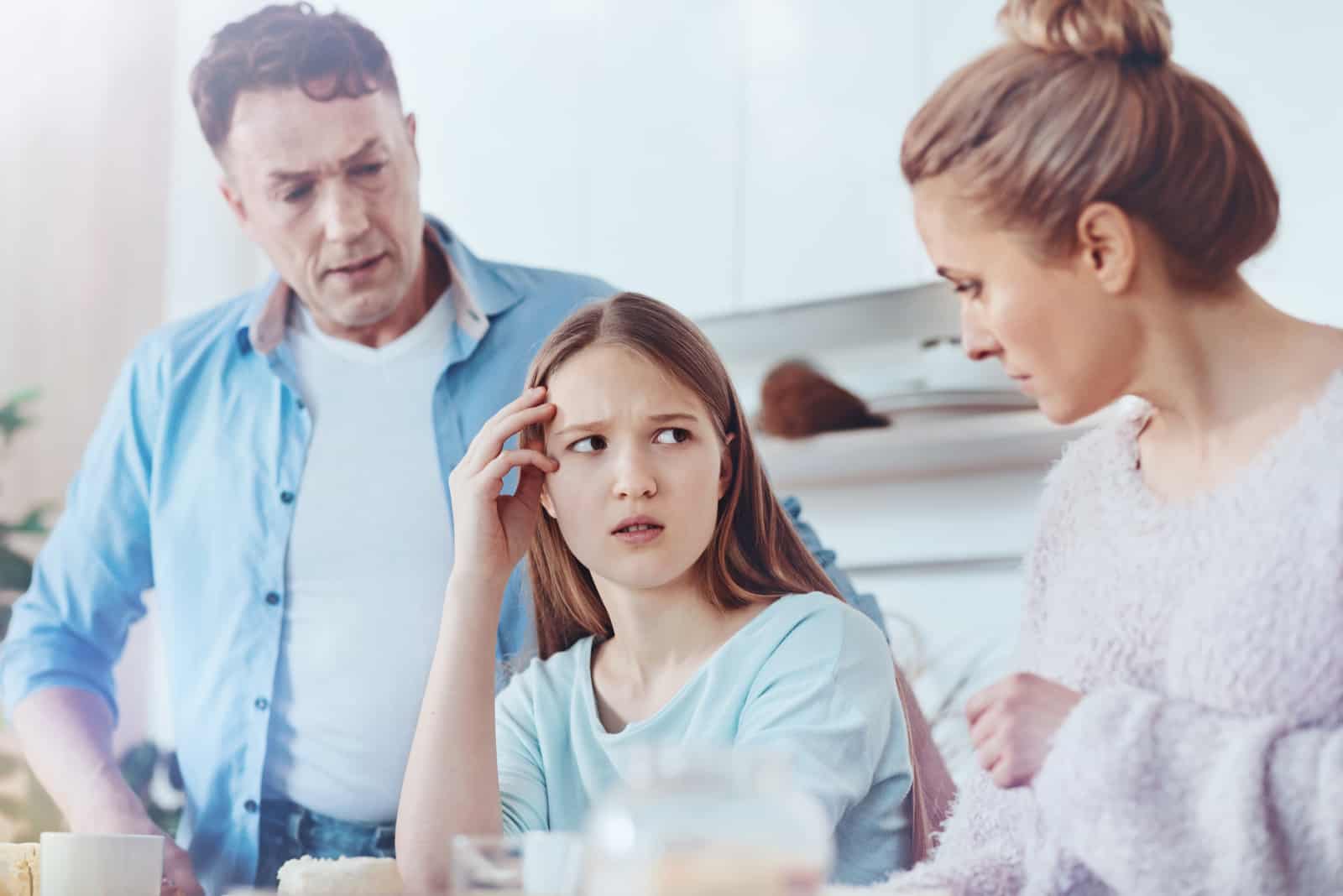 parents parlant à leur fille dans la cuisine