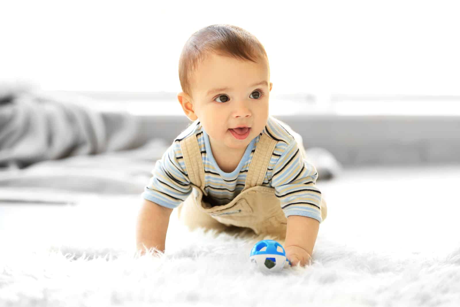 petit garçon rampant jouant avec son jouet
