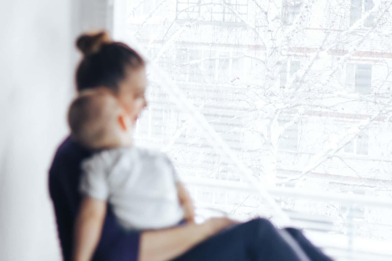 photo floue de la mère et du fils regardant par la fenêtre