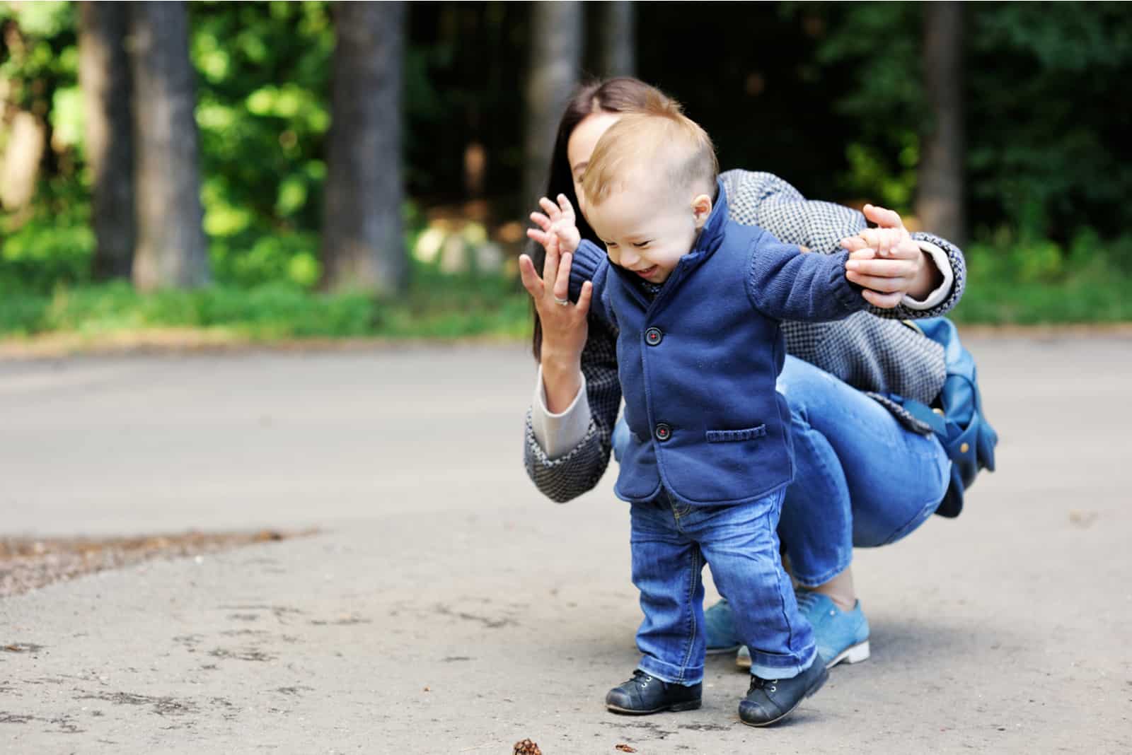 une femme à l'extérieur apprend à un enfant à marcher