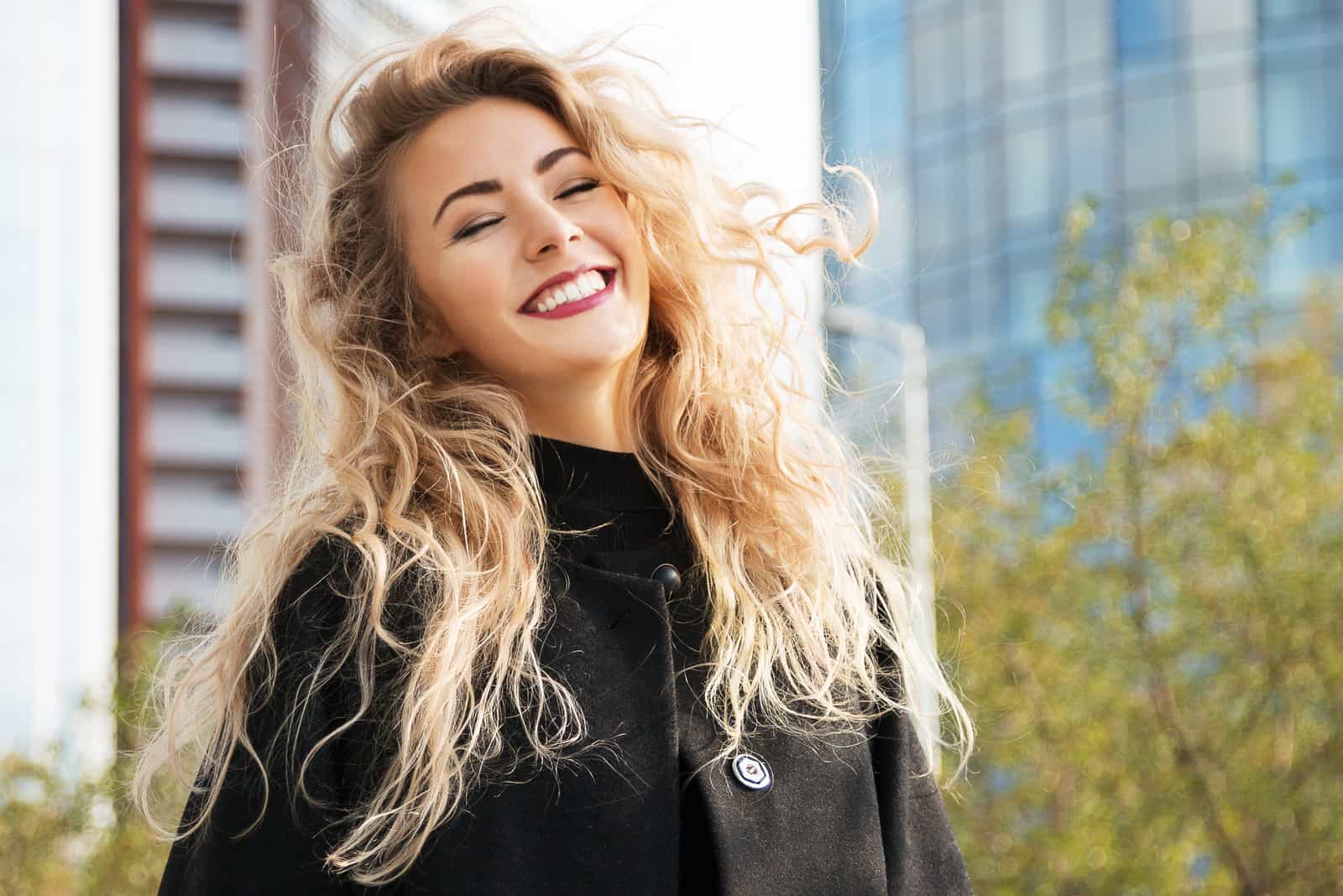 une femme souriante aux longs cheveux blonds