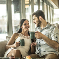 un homme et une femme assis autour d'un café en train de parler