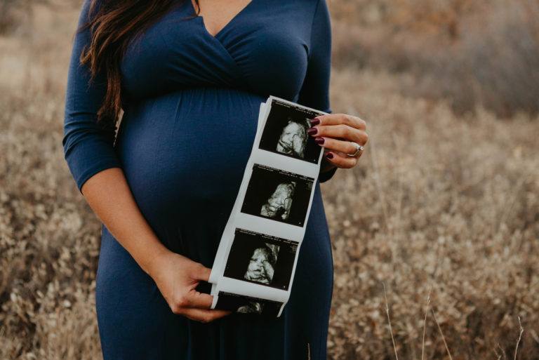 Femme debout dans le champ avec des images échographiques