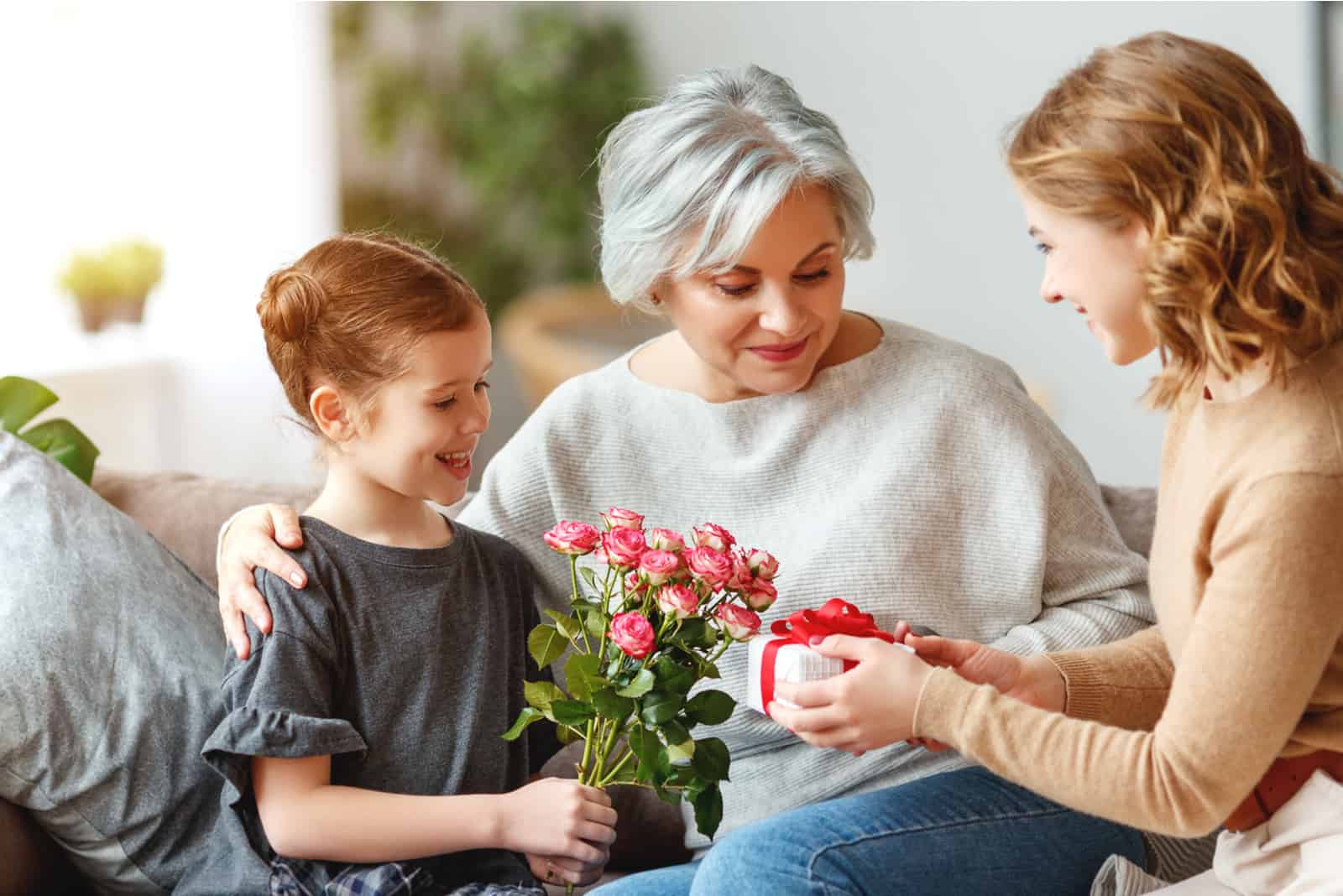 un petit-fils et une maman souriants ont offert un cadeau à grand-mère