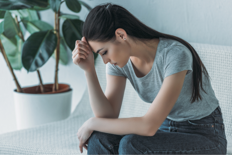 une femme triste assise sur le canapé