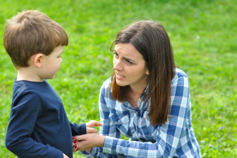 maman tient la main d'un enfant dans le parc et ils parlent