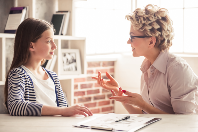 une femme assise à une table avec sa fille et parlant