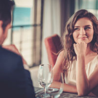 femme souriante regardant l'homme assis avec elle au restaurant