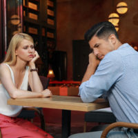 femme triste assise avec un homme indifférent à un rendez-vous