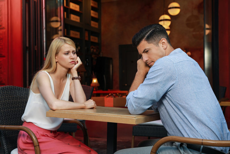 femme triste assise avec un homme indifférent à un rendez-vous