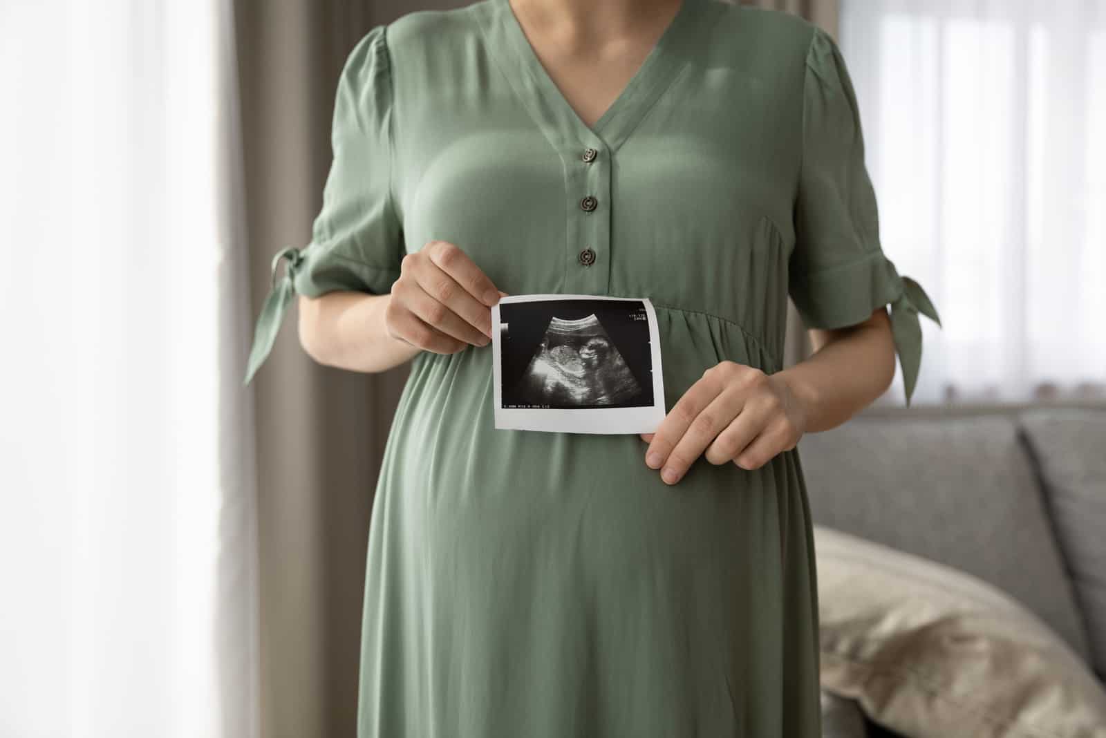 femme enceinte tenant un test de grossesse