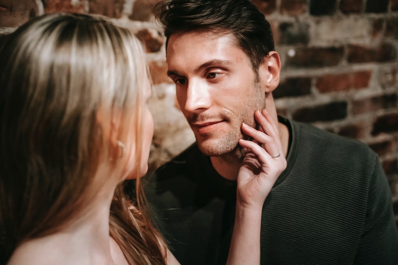 femme touchant le visage de son petit ami et le regardant dans les yeux