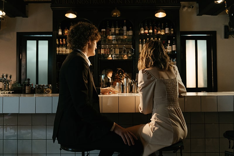 homme et femme assis au comptoir et parlant