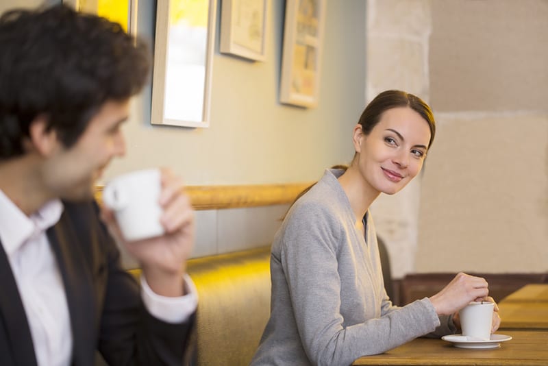 homme et femme se regardant dans les yeux dans le café